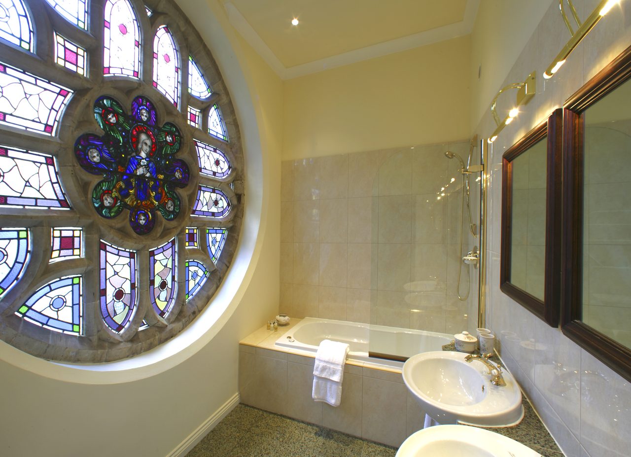 Magnolia suite bathroom with stained glass window at Ashdown Park Hotel